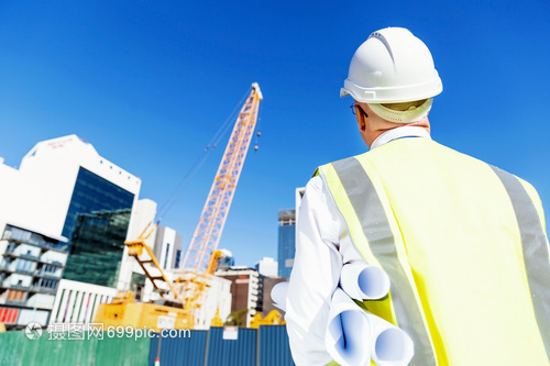 建筑工地的工程師建設(shè)者工程師建筑工人施工場景穿著帶藍(lán)圖的安全背心